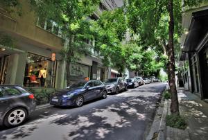 een rij auto's geparkeerd aan de kant van een straat bij Kolonaki Jewel 1st floor feel like home properties in Athene