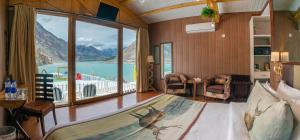 a bedroom with a bed with a view of the water at Luxus Hunza Attabad Lake Resort in Hunza