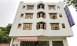 un bâtiment blanc avec des fenêtres et un panneau sur celui-ci dans l'établissement HOTEL SINGH CONTINETAL, à New Delhi