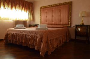 a bedroom with a large bed with two chairs on it at Maison Brinati Bed and Breakfast in Monsummano Terme