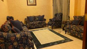 uma sala de estar com sofás e cadeiras e um tapete em فيلا رضوى الخير em Madīnat Yanbu‘ aş Şinā‘īyah