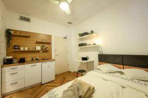 a bedroom with a large bed and a kitchen at Stunning Modern Studio in Netanya minutes from the beach by Sea N' Rent in Netanya