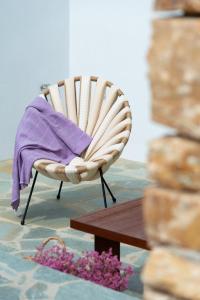 une chaise avec une couverture violette au-dessus dans l'établissement Thimari villas, à Vathi
