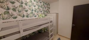 a bedroom with a bed and a wall with plants at Casa vacanze Fantasia - Nuovo! Accogliente appartamento in Barletta