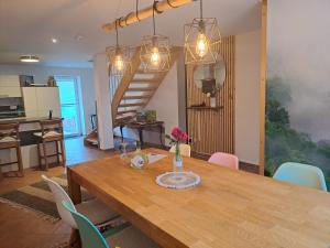 Muhr amSee的住宿－Haus am See，一间带木桌和楼梯的用餐室