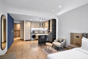 Cet appartement comprend une chambre et un salon avec un lit et une cuisine. dans l'établissement Residence Inn by Marriott Sheikh Zayed Road, Dubai, à Dubaï