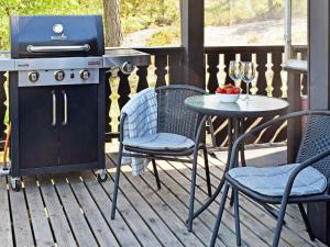een grill op een patio met een tafel en stoelen bij Holiday home Halden IV in Halden