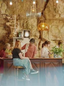 a group of people sitting at a counter in a restaurant at La Boule d'Or - Auberge créative in Clamecy