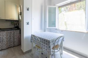 a kitchen with a table with two chairs and a window at Appartamento Ashur Mondello in Palermo