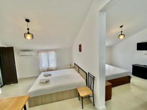 Habitación con 2 camas y mesa. en Magnolia Guest House, en Kobuleti