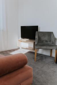 sala de estar con TV y silla en Silesia Apartments, en Katowice