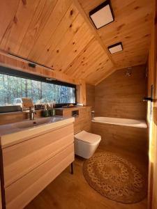 a bathroom with a sink and a tub and a toilet at Szumi Las 