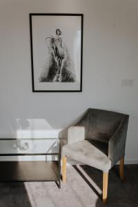 - un salon avec une chaise et une table en verre dans l'établissement Silesia Apartments, à Katowice