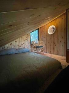 1 dormitorio con 1 cama en una cabaña de madera en Szumi Las, 