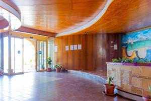 a large lobby with a wooden ceiling and plants at Appartamento Ashur Mondello in Palermo