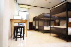 Nong PrueにあるAloft Hotel and Hostel Pattayaの二段ベッド3台とデスクが備わる客室です。