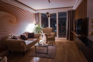 ein Wohnzimmer mit einem Sofa und 2 Stühlen in der Unterkunft Your Place with Spa & Fitness in Skopje