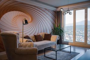 ein Wohnzimmer mit einem Sofa und einem großen Fenster in der Unterkunft Your Place with Spa & Fitness in Skopje