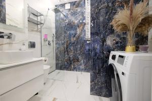 a bathroom with a sink and a washing machine at Apartamenty Centrum Premium Gold in Białystok +39 photos