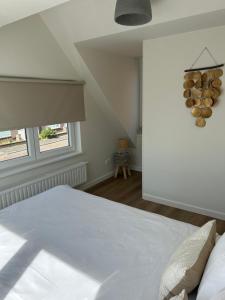 a bedroom with a white bed and a window at Paris Plage - volledig vernieuwd, free parking in Noordwijk aan Zee