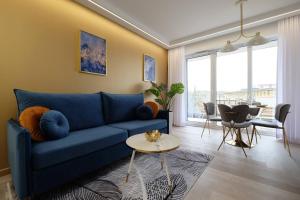 a living room with a blue couch and a table at Apartamenty Centrum Premium Gold in Białystok