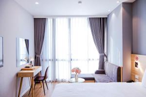 a hotel room with a bed and a desk and a window at IRIS Hotel Hải Phòng in Hai Phong