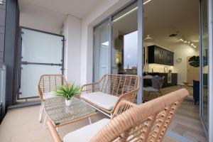 d'un balcon avec des chaises en osier et une table. dans l'établissement Apartamenty Centrum Premium Gold, à Białystok