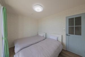 een kleine slaapkamer met 2 bedden en een raam bij KUSUMARU - Vacation STAY 13707v in Ōkachi