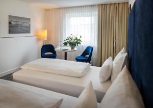維也納的住宿－ARCOTEL Wimberger Wien，酒店客房带两张床和一张桌子以及椅子。