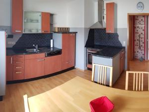 cocina grande con armarios de madera y encimera en Ferienwohnung Oerder, en Meinerzhagen