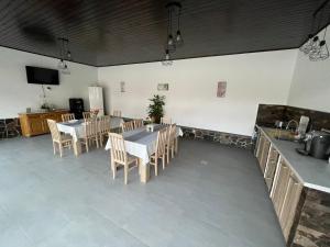 uma sala de jantar com mesas e cadeiras e uma televisão em Tulipán vendégház em Lupeni
