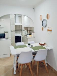 cocina con mesa blanca y sillas blancas en Apartamento Urb La Felicidad, en Denia