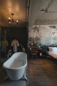 a bathroom with a bath tub and a bedroom at The Chum Boutique in Hue