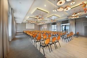 a conference room with a rows of chairs and a podium at Van der Valk Hotel Tiel in Tiel