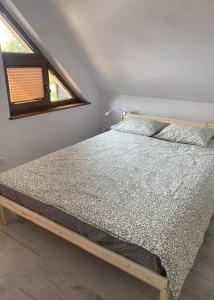 łóżko w sypialni z oknem w obiekcie Brzozowe Wzgórze z jacuzzi i rowerami w Jastrzębiej Górze
