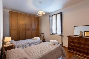 a bedroom with two beds and a dresser at Locanda Da Romano in Cadeo