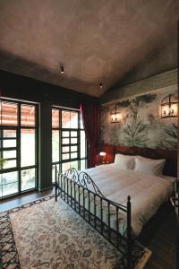 a bedroom with a large bed with a painting on the wall at The Chum Boutique in Hue