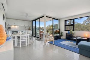 a living room with a kitchen and a dining room at Husky Sol in Huskisson