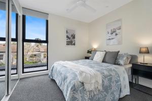 a bedroom with a bed and a large window at Husky Sol in Huskisson