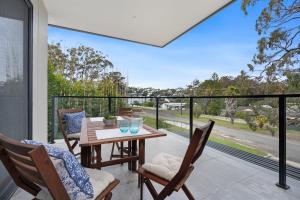 a patio with a table and chairs on a balcony at Husky Sol in Huskisson