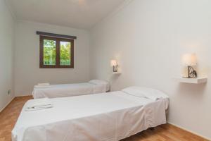 卡普德佩拉的住宿－Villa Arhu，白色客房的两张床,设有窗户
