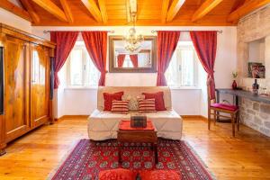 a bedroom with a bed with red curtains and a rug at Luxe Villa Ammarulla in Split