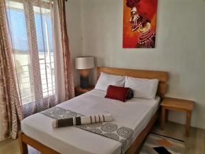 sypialnia z łóżkiem z białą pościelą i oknem w obiekcie OR Saison w mieście Rodrigues Island