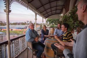 a group of people sitting around a barrel on a balcony at Royal Hotel Sea Lake in Sea Lake