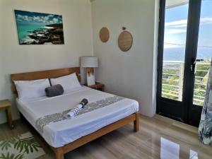 una camera da letto con un letto con vista sull'oceano di OR Saison a Rodrigues Island