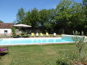 a swimming pool with chairs and an umbrella at Château de Charnizay in Charnizay
