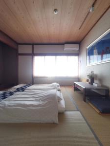 Un dormitorio con una cama grande y una ventana en 心遊亭Shin Yu Tei 一軒雅宿 en Kanazawa