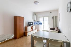 uma sala de estar com uma mesa e cadeiras e uma cama em Condominio Dalla Barbara em Lido di Jesolo