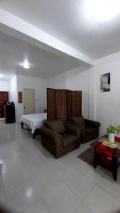 un salon avec un canapé et un lit dans l'établissement Budget Accom Panglao For Family ,Groups, and Friends, à Panglao
