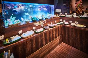 eine Theke mit vielen Schüsseln Nahrung und einem Aquarium in der Unterkunft Hotel Balian Resort Kinshicho in Tokio